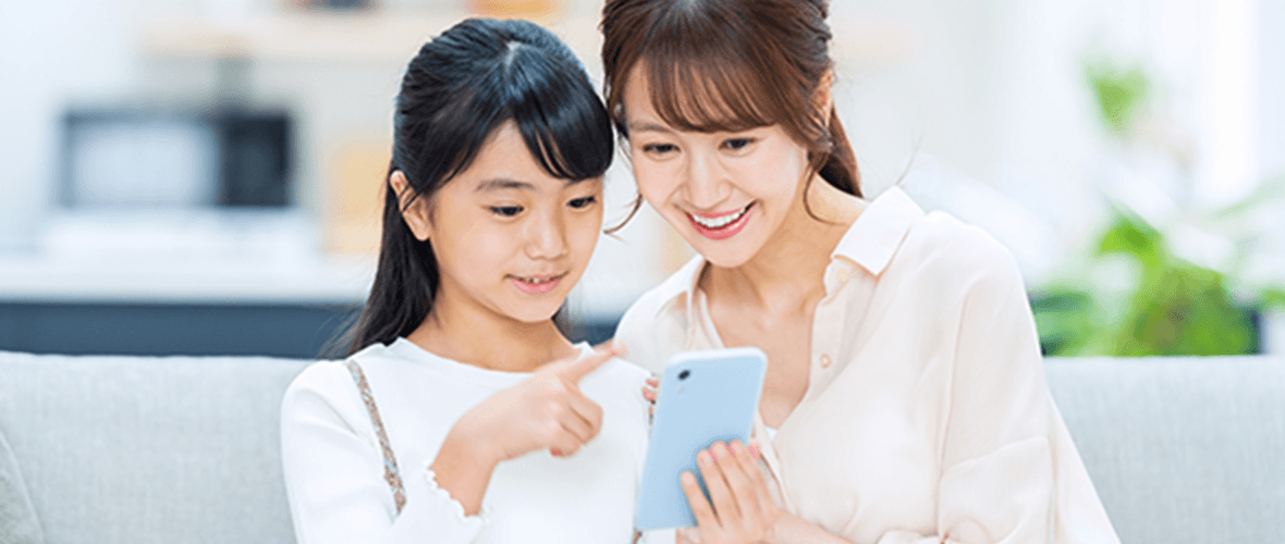 一緒にスマートフォンを見ている親子